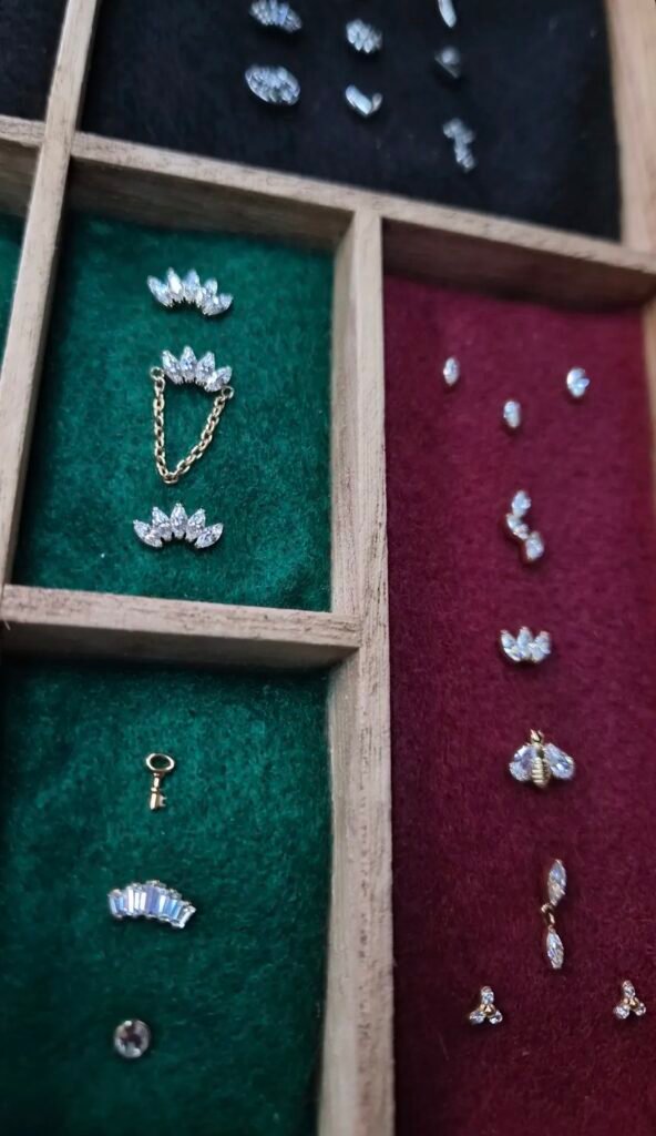 Gemstone piercing jewelry in a divided display tray