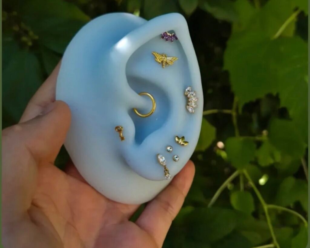 Gold and gemstone jewelry arranged on an ear model