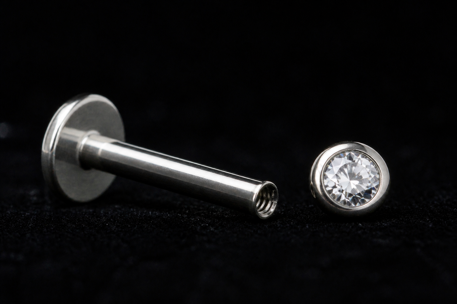 Smooth internally threaded labret post beside a gemstone end